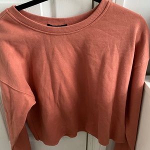 Peach, pink colored cropped sweatshirt